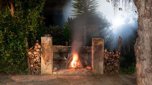 a fire pit with a pile of fire wood at Hotel Rokas de Suesca in Suesca