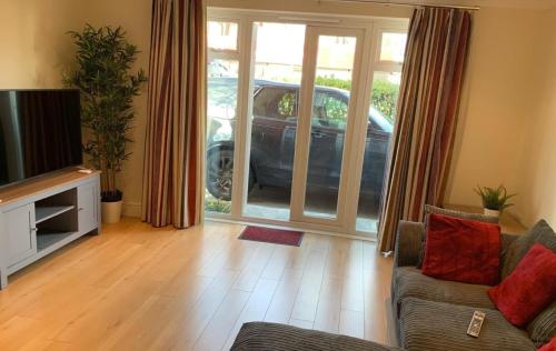 a living room with a couch and a car outside at Addlestone - Stylish and modern 2 bedroom apartment in Addlestone