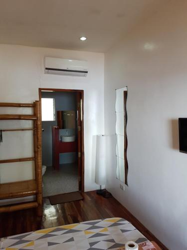 a room with a bed and a room with a mirror at Marianita's cottages in Mambajao
