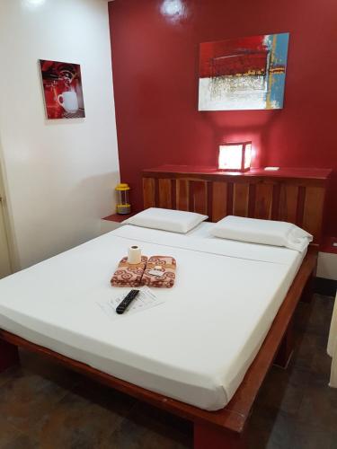 a large white bed in a red room at Marianita's cottages in Mambajao