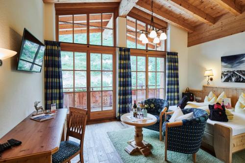 a living room with a couch and a table in a room at Berggasthof Platzlalm in Kaltenbach