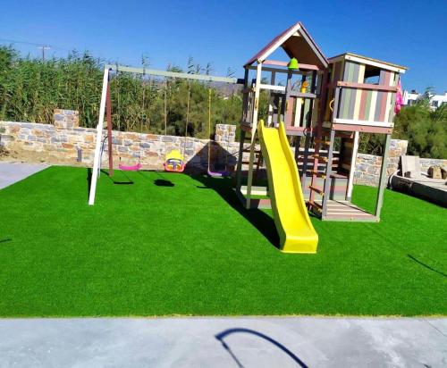 a playground with a slide on the grass at My Naxian Home 1 in Agios Prokopios