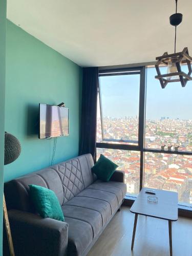 a living room with a couch and a large window at CAN SUIT in Çekmeköy