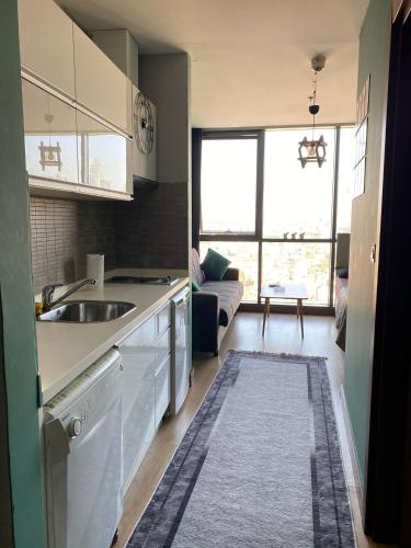 a kitchen with a sink and a living room at CAN SUIT in Çekmeköy