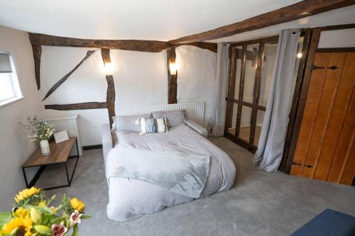 a bedroom with a bed and a table with flowers at Shakespeare's Nest in Stratford-upon-Avon