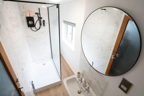 W łazience znajduje się lustro i umywalka. w obiekcie Shakespeare's Nest w mieście Stratford-upon-Avon
