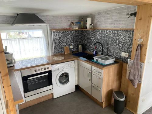 a kitchen with a washing machine and a washer at Bungalow im Grünen in Werneuchen