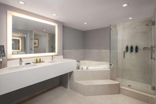 a bathroom with two sinks and a shower and a tub at Hilton Concord in Concord