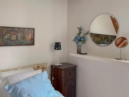 a bedroom with a bed and a mirror on the wall at Casa Luis Pato in Óis do Bairro
