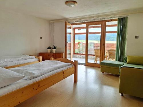 1 Schlafzimmer mit 2 Betten und Blick auf einen Balkon in der Unterkunft Apartmán pod Maliarkou in Východná