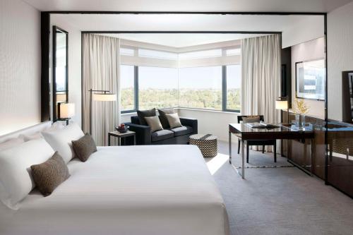 柏斯的住宿－珀斯大都會皇冠酒店，酒店客房设有一张大床和一张书桌。