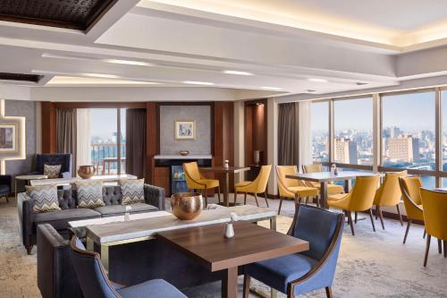 a hotel lobby with tables and chairs and windows at Ramses Hilton Hotel & Casino in Cairo