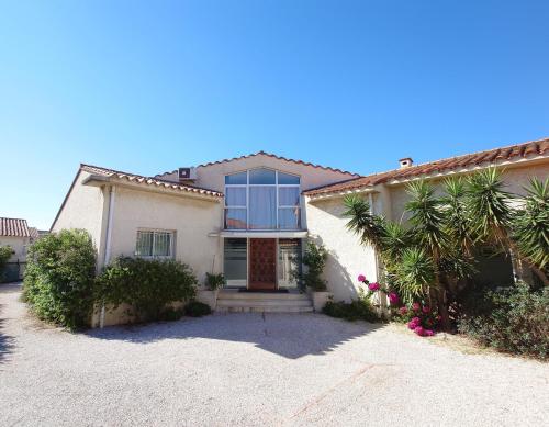 une maison blanche avec une porte et quelques plantes dans l'établissement Chambres d'hôtes 