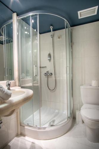 a bathroom with a shower and a sink and a toilet at Olympic Hotel in Heraklio Town