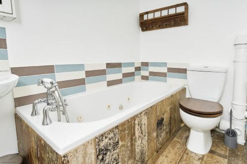 a bathroom with a tub and a toilet at 28 Marsh Road in Gurnard