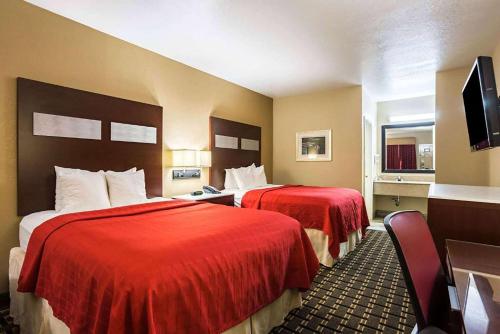 ein Hotelzimmer mit 2 Betten mit roter Bettwäsche in der Unterkunft Hotel Oxford, a Travelodge by Wyndham in Oxford