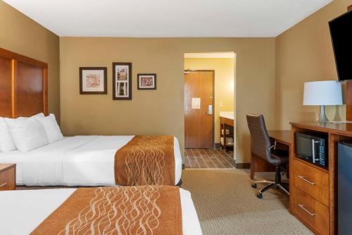 a hotel room with a bed and a desk and a television at Comfort Inn North-Polaris in Columbus
