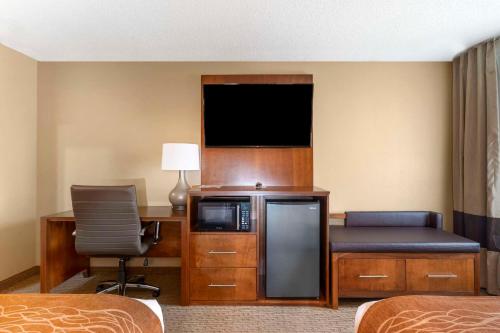 a hotel room with a television and a desk with a chair at Comfort Inn North-Polaris in Columbus