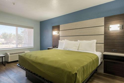 Quality Inn & Suites Manitou Springs at Pikes Peak في مانيتو سبرينغز: غرفة نوم بسرير كبير ونافذة كبيرة