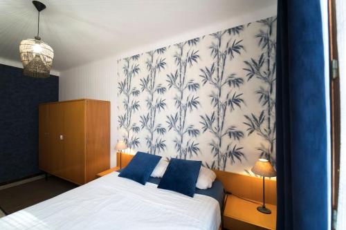 - une chambre dotée d'un lit avec du papier peint bleu et blanc dans l'établissement Appartement La Côte bleue à L'Estaque, à Marseille