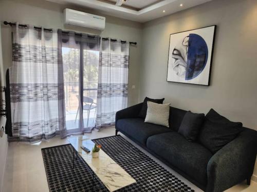 a living room with a black couch and windows at Elegant 1 bedroom apartment at Aquaview in Bathurst