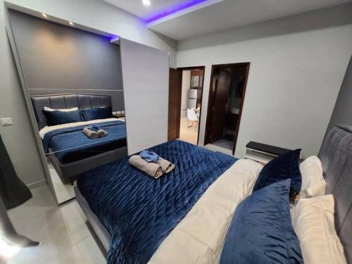 - une chambre avec 2 lits avec des draps bleus et blancs dans l'établissement Elegant 1 bedroom apartment at Aquaview, à Banjul