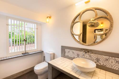 a bathroom with a white toilet and a mirror at 55TG Boutique Suites in Colombo
