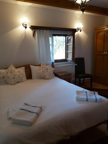 a bedroom with a large white bed with towels on it at Casa de vacanta Padis in Breb
