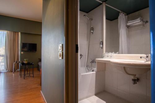 y baño con lavabo y ducha. en Olympic Hotel, en Heraclión