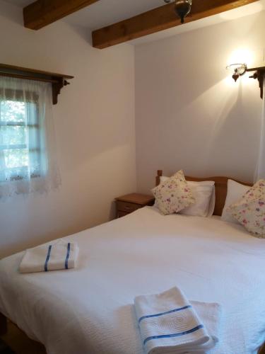 a bedroom with a white bed with two towels on it at Casa de vacanta Padis in Breb