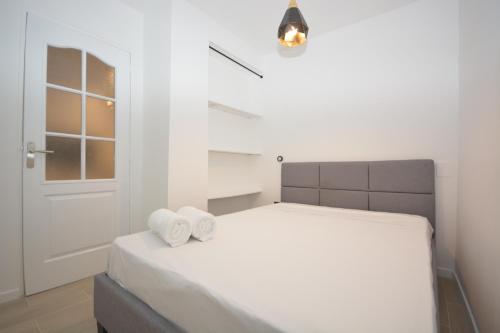 a white bedroom with a bed with two towels at 1 Bedroom RDC - Sacre Coeur in Paris