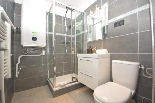 une salle de bain avec toilettes et douche en verre dans l'établissement 1 Bedroom RDC - Sacre Coeur, à Paris