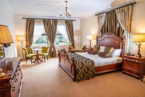 a bedroom with a bed and a table and chairs at An Chúirt Hotel, Gweedore, Donegal in Gweedore