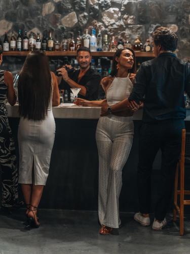 a group of people standing around a bar at Divino Caldera in Akrotiri