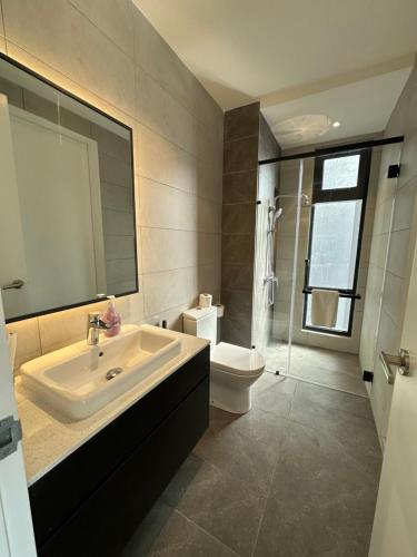 a bathroom with a sink and a toilet and a mirror at AXON Suites Bukit Bintang By Sky Pool in Kuala Lumpur