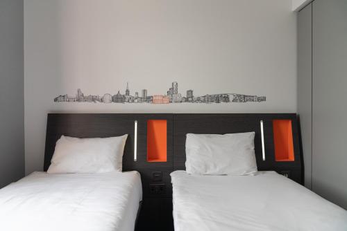 two beds sitting next to each other in a room at easyHotel Ipswich in Ipswich
