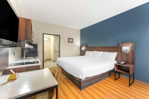 a hotel room with a large bed and a tv at Suburban Studios LaVale - Cumberland in La Vale