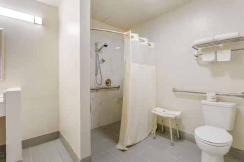 a bathroom with a toilet and a shower at Suburban Studios LaVale - Cumberland in La Vale