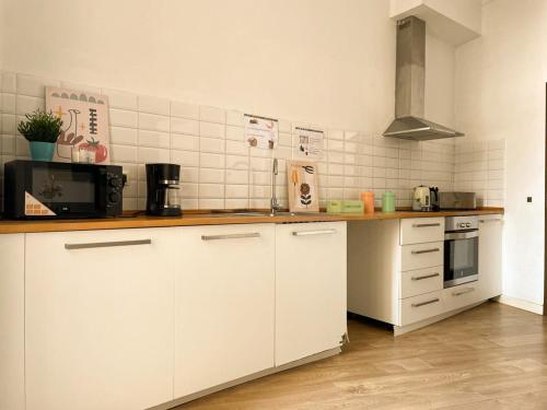 cocina con armarios blancos y encimera en By La Rambla Rooms, en Barcelona