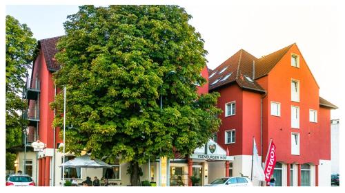 a large tree in front of a red building at Konferenzhotel Ysenburger Hof in Langenselbold