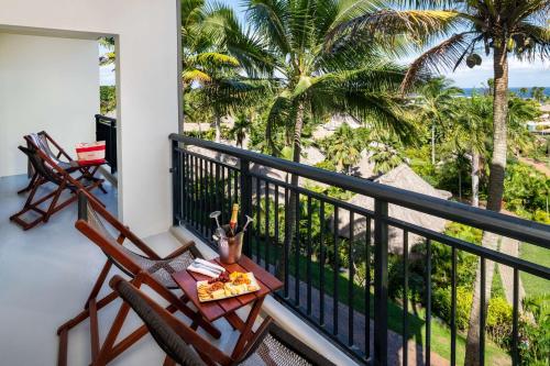 a balcony with two chairs and a table with food on it at Outrigger Fiji Beach Resort in Korotogo