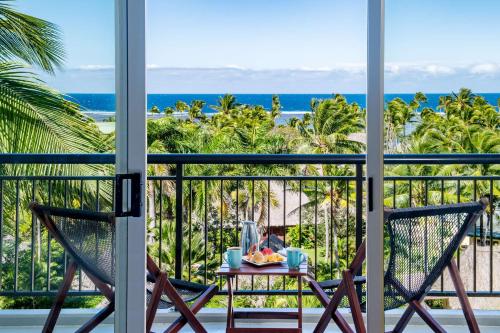 a table and two chairs on a balcony with the ocean at Outrigger Fiji Beach Resort in Korotogo