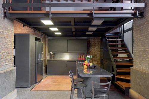 a kitchen with a table and chairs and a staircase at Santa Cecilia Loft in Rome