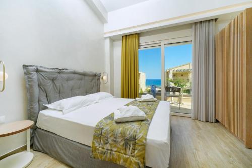 a bedroom with a bed and a view of the ocean at ILIORAMA LUXURY SUITES in Skala Potamias