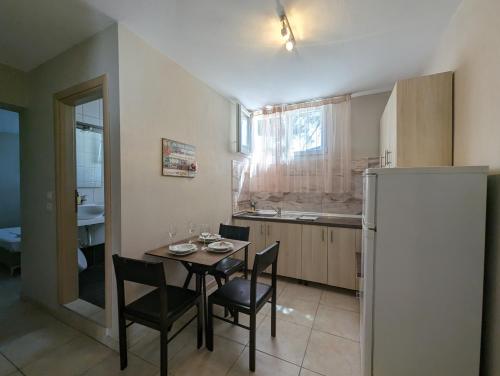 eine Küche mit einem Tisch und Stühlen sowie einem Kühlschrank in der Unterkunft DeniaStella villas in Skala Potamias