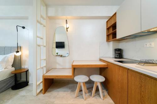 una pequeña cocina con 2 taburetes en una pequeña habitación en ILIORAMA LUXURY SUITES, en Skala Potamias