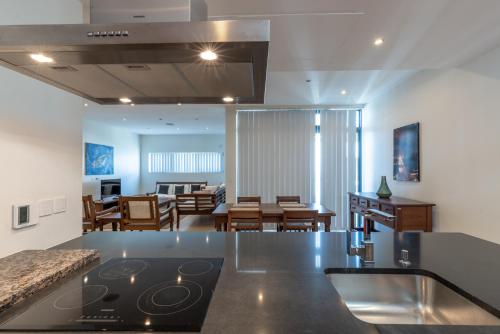 uma cozinha e sala de estar com uma placa de fogão e forno em English Point Marina Luxe C405 em Mombaça