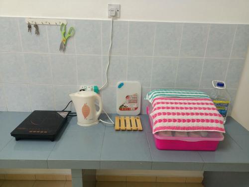 a counter top with a pink and white blanket and a blender at Celine's Homestay in Taiping