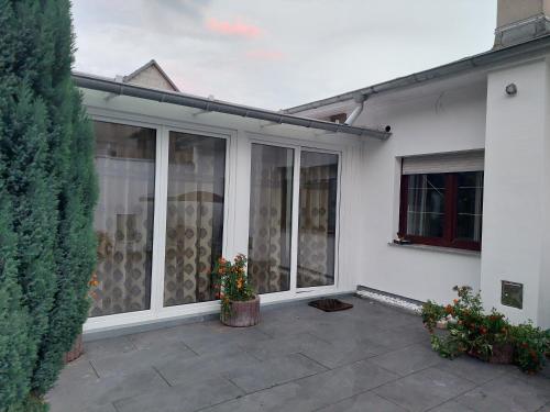 a white house with sliding glass doors on a patio at Hotel Restaurant Rhodos in Elsterwerda