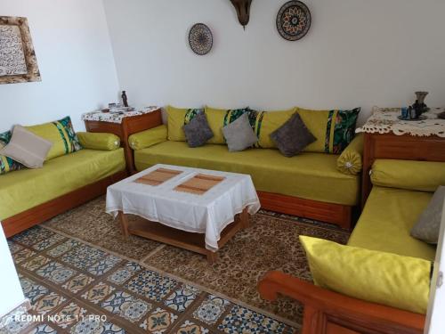 a living room with two couches and a table at Maison Berj in Oualidia